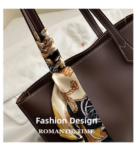 Detail of dark brown tote bag featuring white contrast stitching and a vintage silk scarf handle
