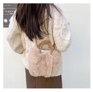 Detail of plush faux fur handbag with braided handle on female model's shoulder
