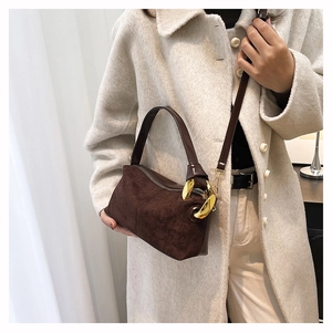Dettaglio borsa a mano in pelle scamosciata marrone con catena dorata e tracolla chic