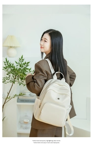 Detail of cream nylon backpack with multiple zipper pockets for urban commuting