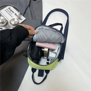 Mini contrast crossbody bag in neon yellow and navy blue showing interior storage capacity