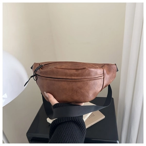 Detail of vintage brown waist bag with textured faux leather and black zipper closure