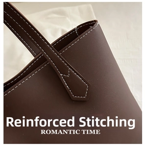 Close-up of white contrast stitching and reinforced handle on dark brown leather tote bag