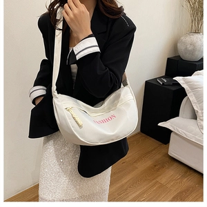 Adjustable wide strap on a white nylon crescent crossbody bag with pink lettering