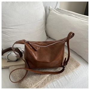 Macro shot of dark brown soft leather texture and silver metal zipper on tote bag