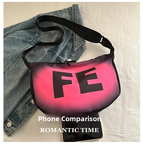 Size comparison of the gradient crescent bag with a smartphone on denim background