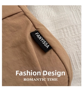 Close-up of the woven brand label on a khaki casual shoulder bag with fine stitching