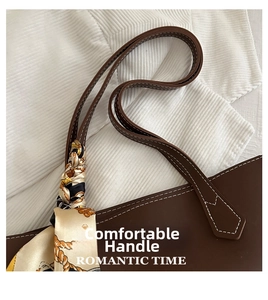 Detail of dark brown leather tote bag with white stitching and decorative floral silk scarf