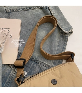 Détail du sac en nylon kaki avec coutures en V et large bandoulière réglable