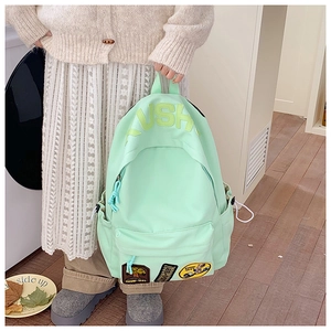 Detail of light green canvas backpack with vintage embroidery and VSH logo on front