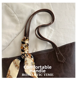 Detail of vintage brown tote bag handle with silk scarf and white contrast stitching
