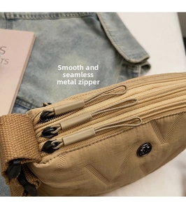 Détail de la texture matelassée en nylon kaki et fermetures éclair multicouches