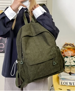 Detail of dark green corduroy backpack showing retro texture and spacious side pockets
