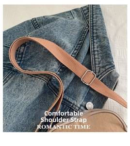 Detail view of the adjustable wide woven shoulder strap on a chic beige crossbody bag