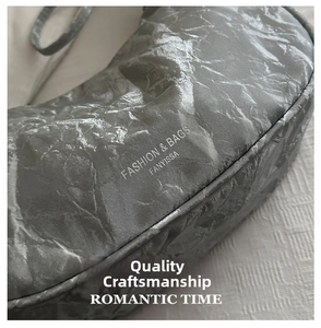 Detailed macro view showing the unique crinkled metallic texture of the silver crescent bag