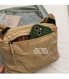 Détail de la poche zippée antivol au dos du sac bandoulière matelassé kaki