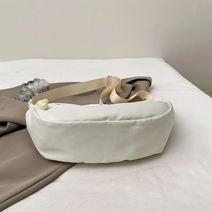 Minimalist cream white nylon crescent crossbody bag with woven zipper detail and wide strap