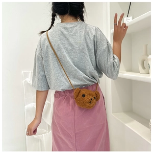 Vue arrière d'un enfant portant un sac bandoulière ourson mignon en peluche de laine