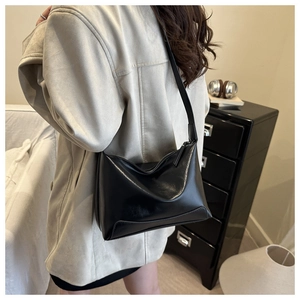 Minimalist black faux leather tote bag shown in lifestyle urban casual style outfit
