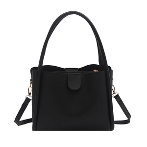Minimalist black matte leather bucket bag with top handle and adjustable shoulder strap