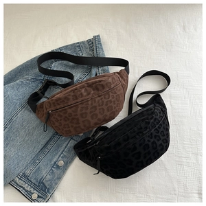 Detail of two leopard print canvas chest bags in brown and black on denim fabric