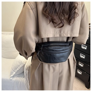 Close-up of black PU leather waist bag on model showing premium texture and zipper detail