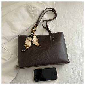 Détail d'un sac cabas marron foncé en cuir PU vintage avec foulard en soie et téléphone