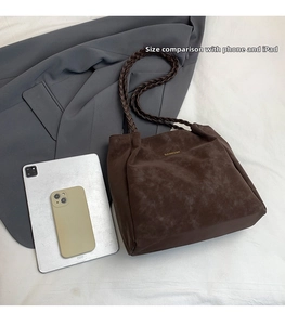 Detail of dark brown tote bag capacity compared with tablet and mobile phone
