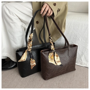 Détail de sacs cabas en cuir avec texture grainée et foulards en soie vintage décoratifs
