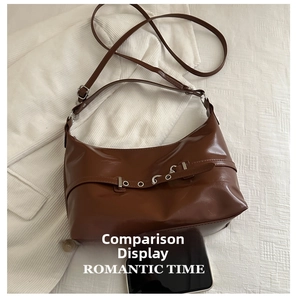 Detail view of the brown leather shoulder bag with adjustable silver buckle strap