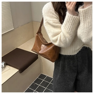 Borsa tote vintage marrone in pelle lucida indossata da una modella in stile casual