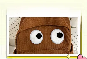 Detailed view of caramel corduroy backpack featuring a cute cartoon big eyes patch