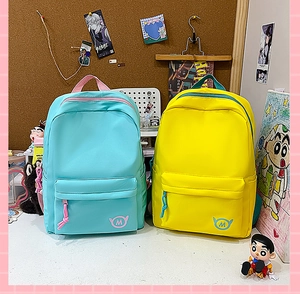Detail view of mint blue and lemon yellow school backpacks with front zip pockets