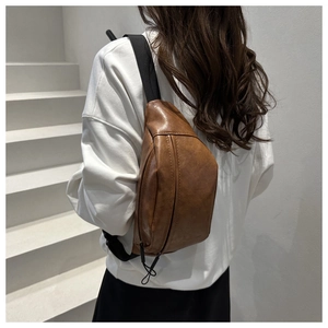 Close-up of brown PU leather crossbody bag with adjustable strap and vintage texture