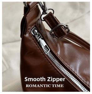 Detailed close-up of smooth silver zipper and hardware on a brown leather handbag