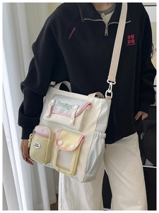 Detail of multi-pocket college style crossbody bag with color-block nylon fabric
