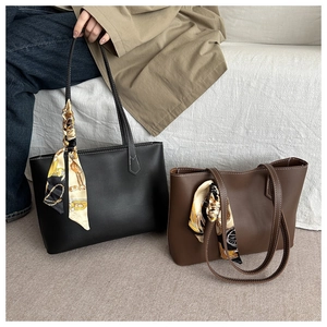 Close-up of minimalist tote bag with premium matte leather and elegant silk scarf detail