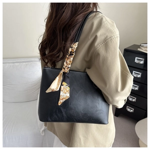 Détail du sac cabas en cuir noir avec surpiqûres et foulard en soie imprimé décoratif