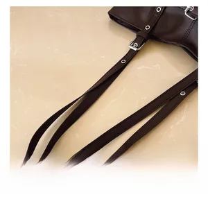 Detail of dark brown tote bag strap with silver buckle and metal eyelet hardware