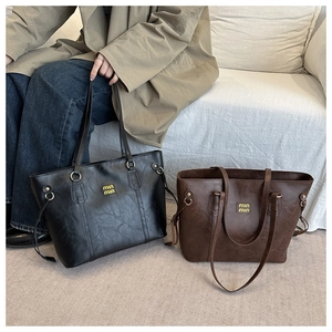 Detail showing vintage oversized tote bags in black and dark brown with logo and drawstrings