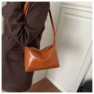Detail view of the orange-brown vintage faux leather tote with reinforced stitching