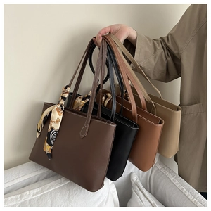 Detail of four colorful faux leather tote bags with silk scarf and slim handles