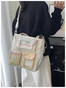 Close-up of canvas messenger bag with multi-color pockets and Lucky Duo Ning text