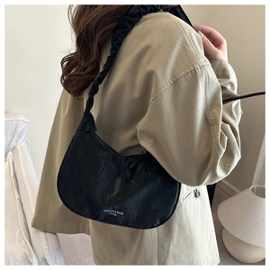 Detail of black nylon cloud bag featuring unique ruched texture and scrunchie strap design