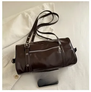 Size comparison of dark brown glossy barrel bag with a smartphone on corduroy background