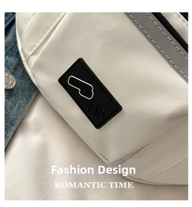 Close-up of white nylon waist bag featuring a black logo patch and reflective gray trim