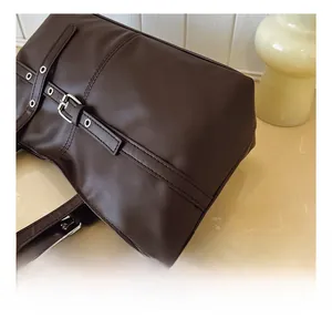 Detailed close-up of dark brown soft PU leather tote with adjustable metal buckle details