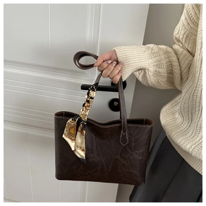 Close-up of retro brown tote bag with wrinkled texture and decorative silk scarf detail