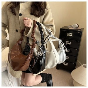 Detail of hobo bag pleated shoulder straps in brown, black, beige and silver colors