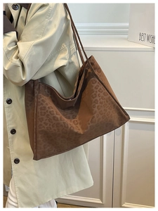 Close-up of leopard print tote bag on shoulder, showcasing soft suede texture and long straps